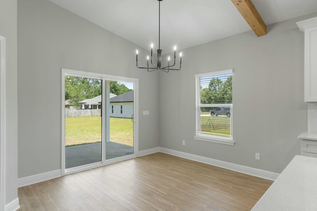 unfurnished dining area featuring vaulted ceiling with beams, light wood-type flooring, and baseboards