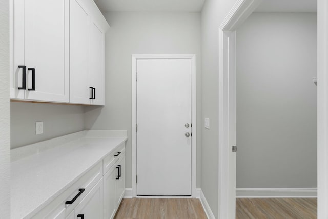 interior space with light wood finished floors and baseboards