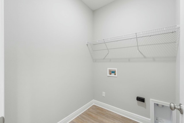 clothes washing area with laundry area, baseboards, light wood-type flooring, washer hookup, and electric dryer hookup