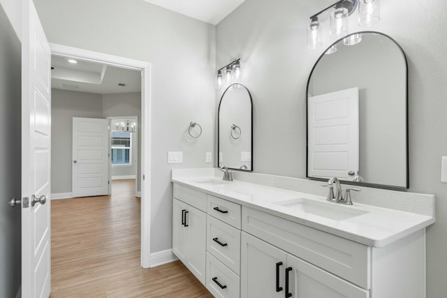 full bath featuring baseboards, a sink, and wood finished floors