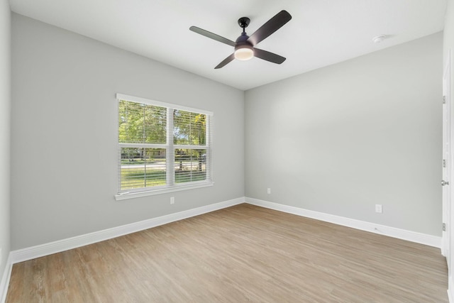 unfurnished room featuring ceiling fan, light wood-type flooring, and baseboards