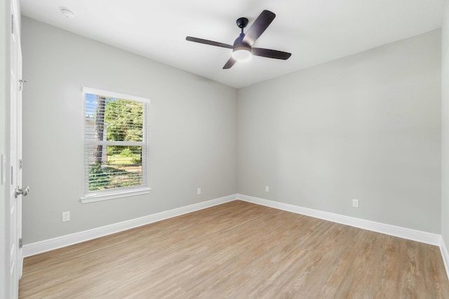 empty room featuring light wood-style floors, a ceiling fan, and baseboards