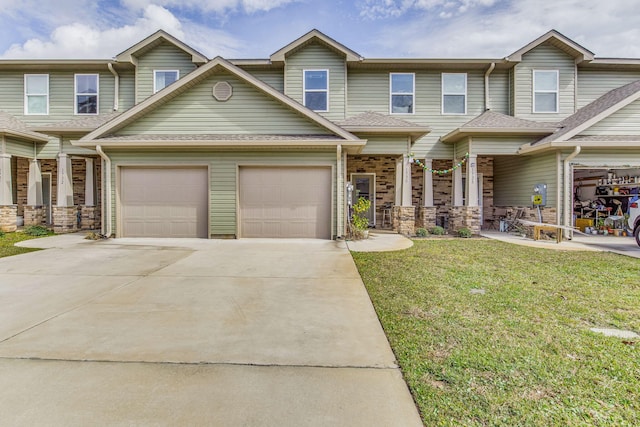 view of front facade with driveway, an attached garage, a shingled roof, and a front yard