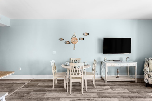 unfurnished dining area with wood finished floors and baseboards