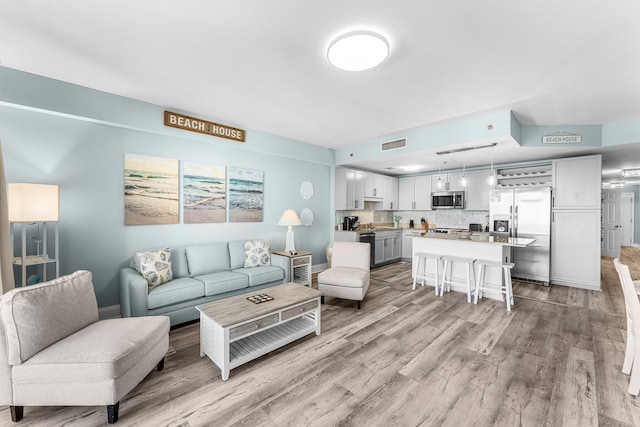 living area with visible vents and light wood finished floors