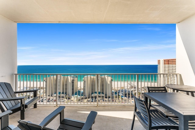 balcony featuring a beach view and a water view