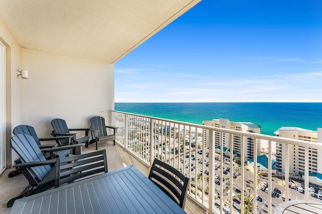 balcony featuring a view of the beach and a water view