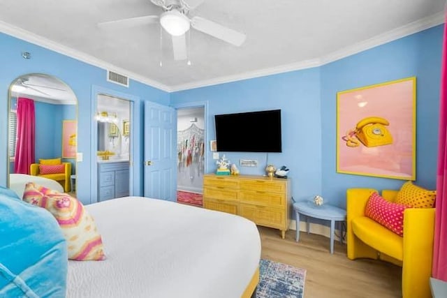 bedroom featuring ceiling fan, connected bathroom, wood finished floors, visible vents, and crown molding