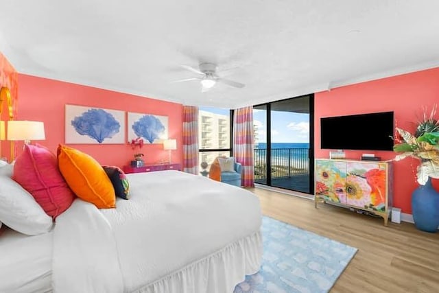 bedroom featuring access to outside, floor to ceiling windows, ceiling fan, and wood finished floors