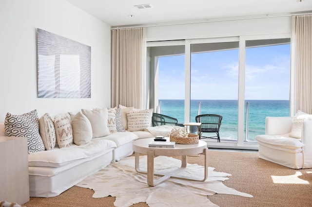 living room with a water view and visible vents