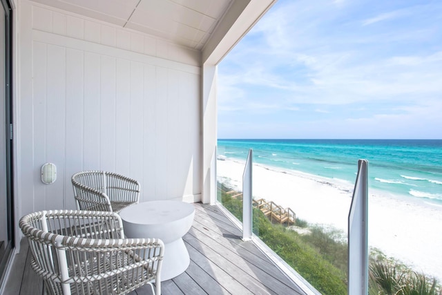 balcony featuring a water view and a view of the beach