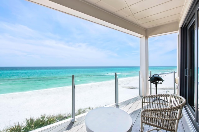 balcony featuring a beach view and a water view