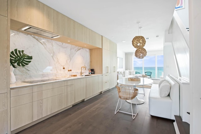 kitchen featuring black electric stovetop, dark wood-type flooring, a sink, decorative backsplash, and light brown cabinetry