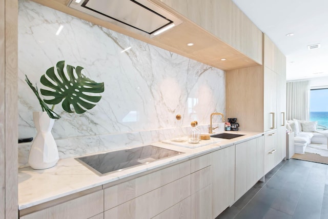 kitchen with visible vents, modern cabinets, black electric stovetop, and a sink