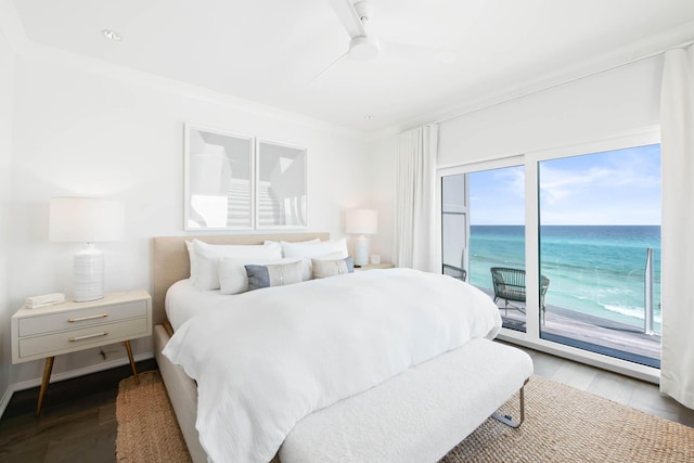 bedroom with ceiling fan, wood finished floors, a water view, access to exterior, and crown molding