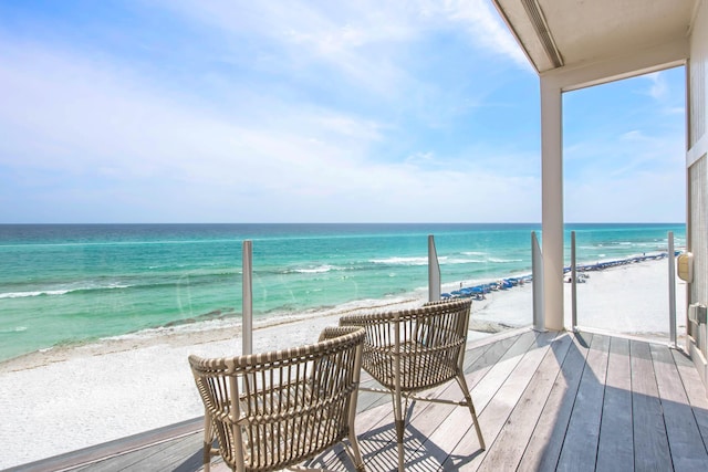 balcony featuring a water view and a view of the beach