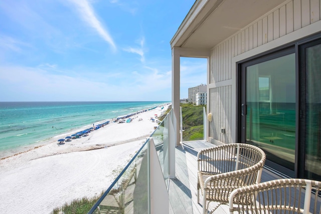 balcony featuring a water view and a beach view