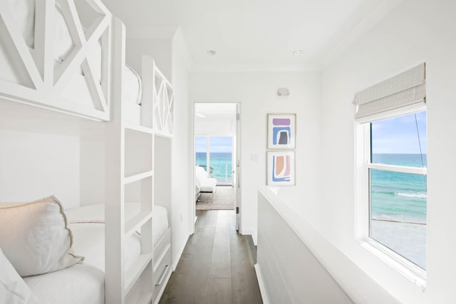 hall with a wealth of natural light, a water view, and dark wood finished floors