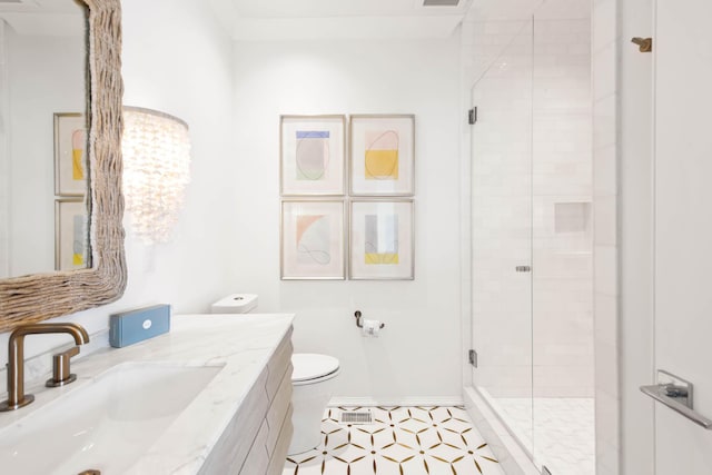 bathroom with a stall shower, baseboards, vanity, and toilet