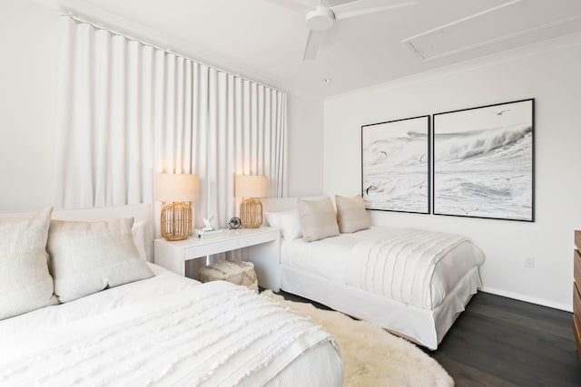 bedroom featuring ceiling fan, wood finished floors, baseboards, ornamental molding, and attic access