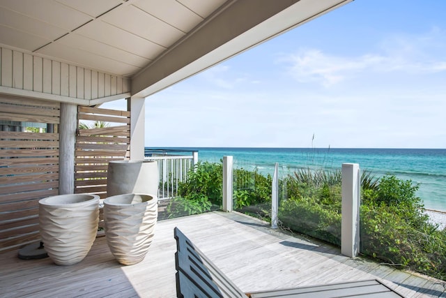 wooden deck featuring a water view and a beach view