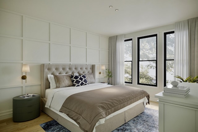 bedroom featuring a decorative wall and light wood-style floors