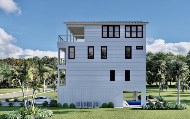 exterior space with a lawn, metal roof, and a balcony