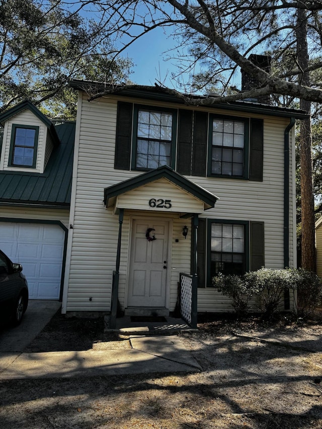 traditional-style house featuring driveway and metal roof