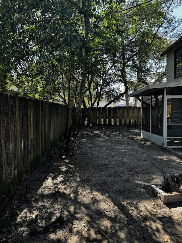 view of yard featuring a fenced backyard and a sunroom