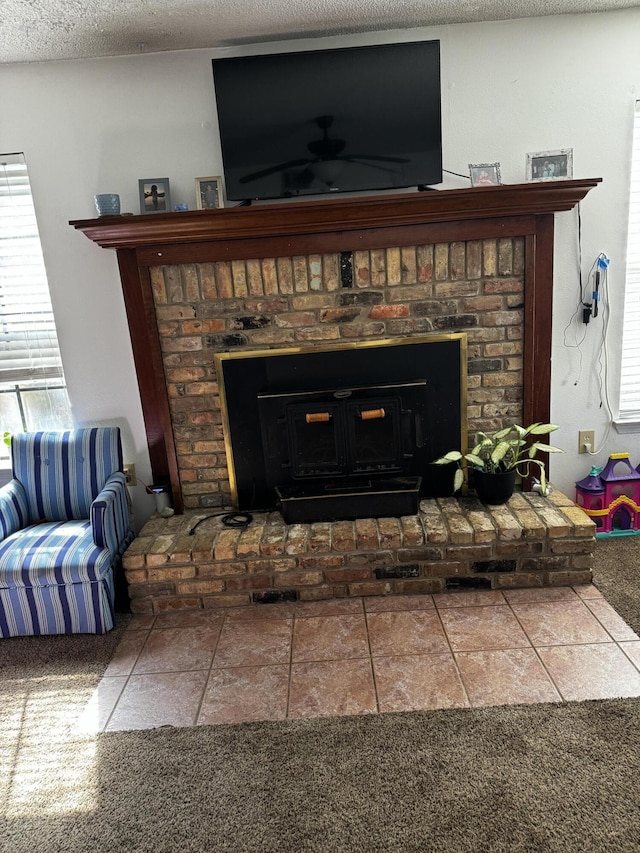 room details with a fireplace, a ceiling fan, and a textured ceiling