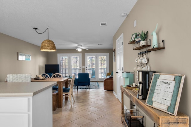 office space with a ceiling fan, visible vents, a textured ceiling, and light tile patterned floors