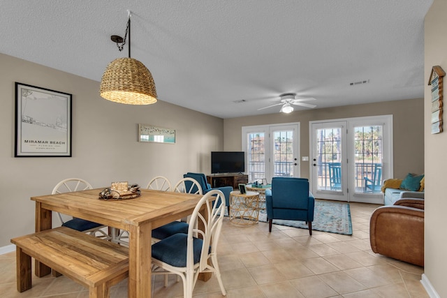 dining area featuring visible vents, ceiling fan, a textured ceiling, and light tile patterned floors