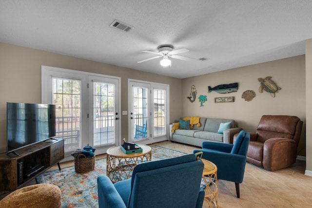 living area with a ceiling fan, visible vents, a textured ceiling, and light tile patterned floors