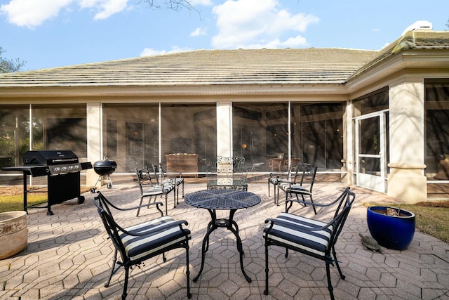 view of patio / terrace with a sunroom and a grill