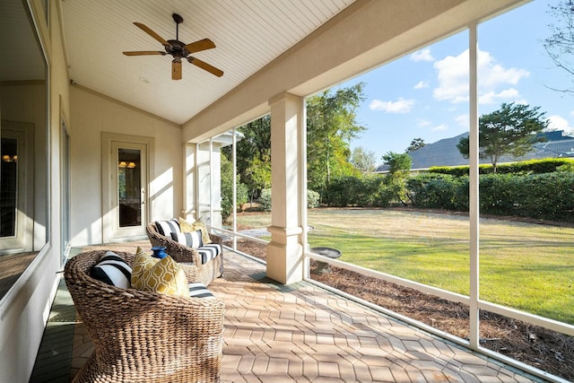 unfurnished sunroom featuring lofted ceiling and a ceiling fan