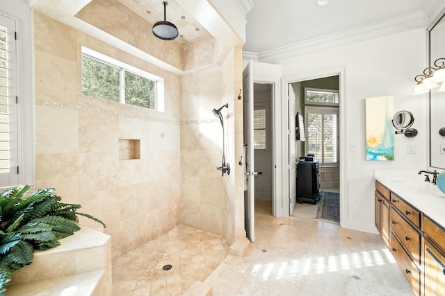 bathroom with plenty of natural light, vanity, crown molding, and tiled shower