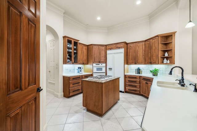 kitchen with crown molding, a sink, paneled built in fridge, and open shelves