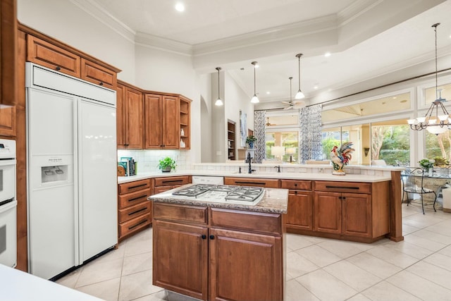 kitchen with backsplash, crown molding, paneled built in fridge, and a peninsula