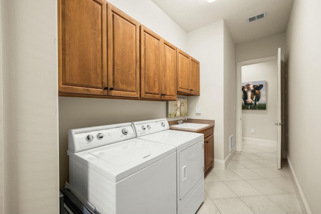 clothes washing area with cabinet space, a sink, visible vents, and washing machine and clothes dryer