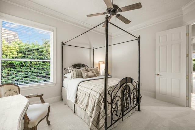 carpeted bedroom featuring ornamental molding, ceiling fan, and baseboards