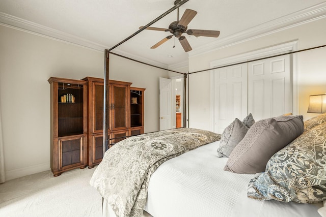 bedroom with a closet, light colored carpet, ornamental molding, a ceiling fan, and baseboards