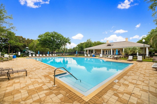 pool featuring fence and a patio