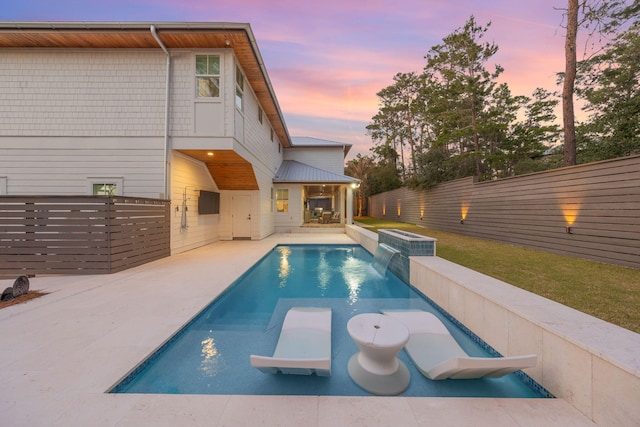 pool at dusk featuring a patio area, a fenced backyard, and a fenced in pool