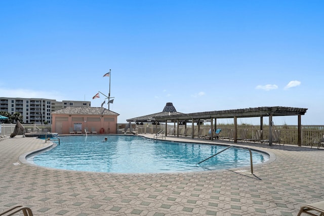 community pool featuring fence, a pergola, and a patio