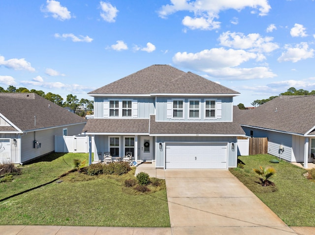 traditional-style house with concrete driveway, a shingled roof, a front yard, and fence