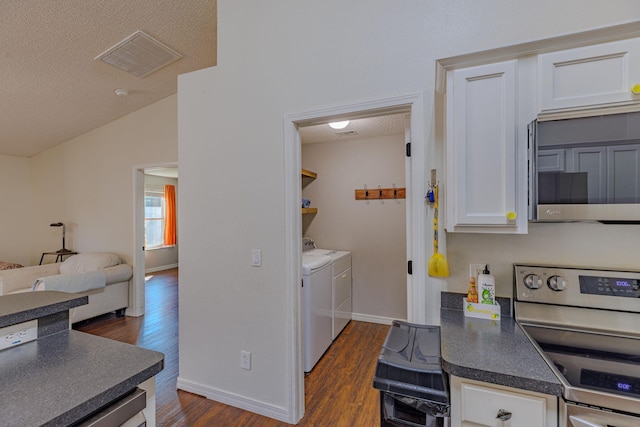 kitchen with dark wood finished floors, visible vents, appliances with stainless steel finishes, white cabinetry, and independent washer and dryer