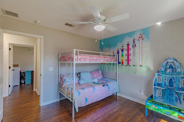 bedroom with a textured ceiling, wood finished floors, and visible vents