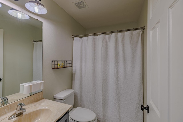 full bathroom with toilet, vanity, and visible vents