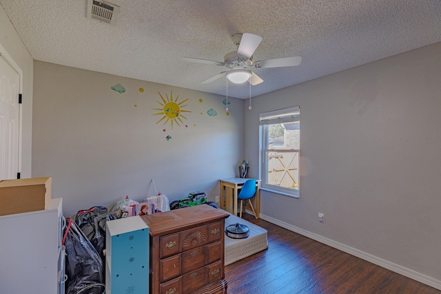 interior space with baseboards, visible vents, ceiling fan, wood finished floors, and a textured ceiling