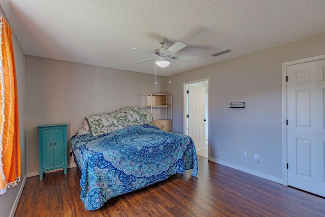 bedroom with a textured ceiling, wood finished floors, visible vents, and baseboards